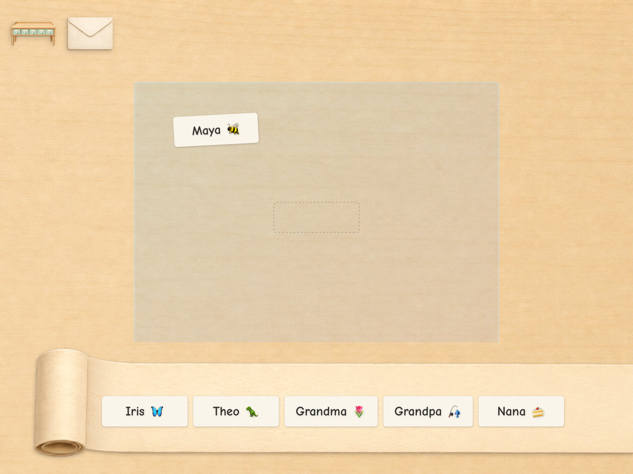 An envelope on the desk carrying a From sticker, with a roll of address labels — Iris, Theo, Grandma, Grandpa, Nana — waiting below